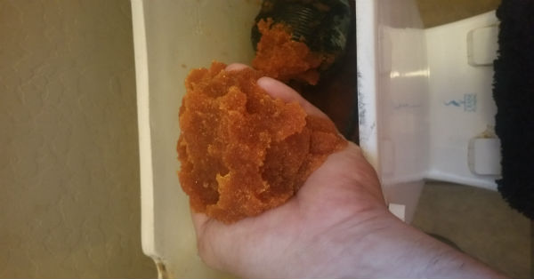 Water softener residue in a man's hand - Robins Plumbing, Inc.